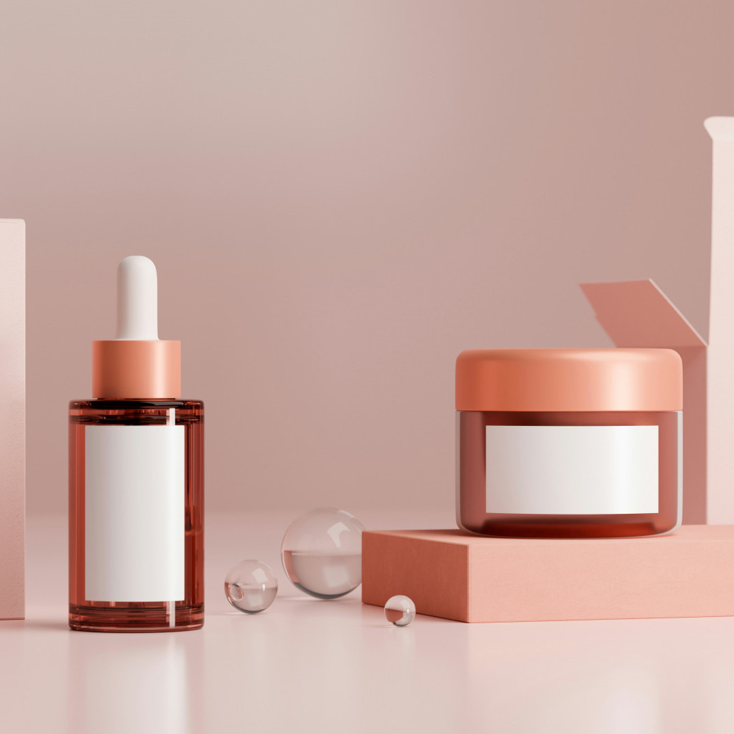 Eine Creme und ein Fläschchen Serum stehen auf einem Tisch neben ihren Verpackungen. Sie sind ohne Marke.